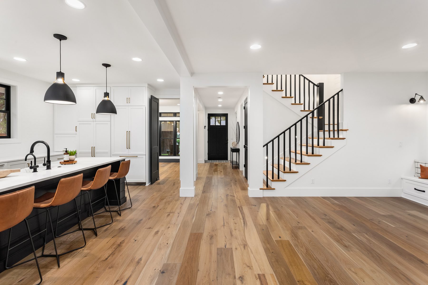 Wide-plank hardwood flooring installed through a kitchen and hallway